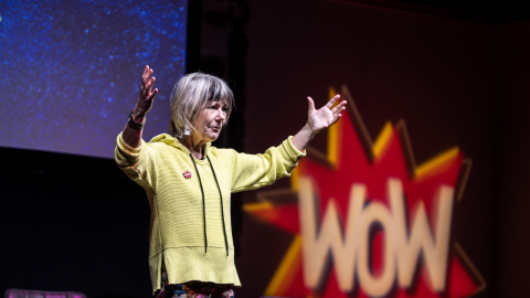 Speaker from Women of the World Festival stands on stage.