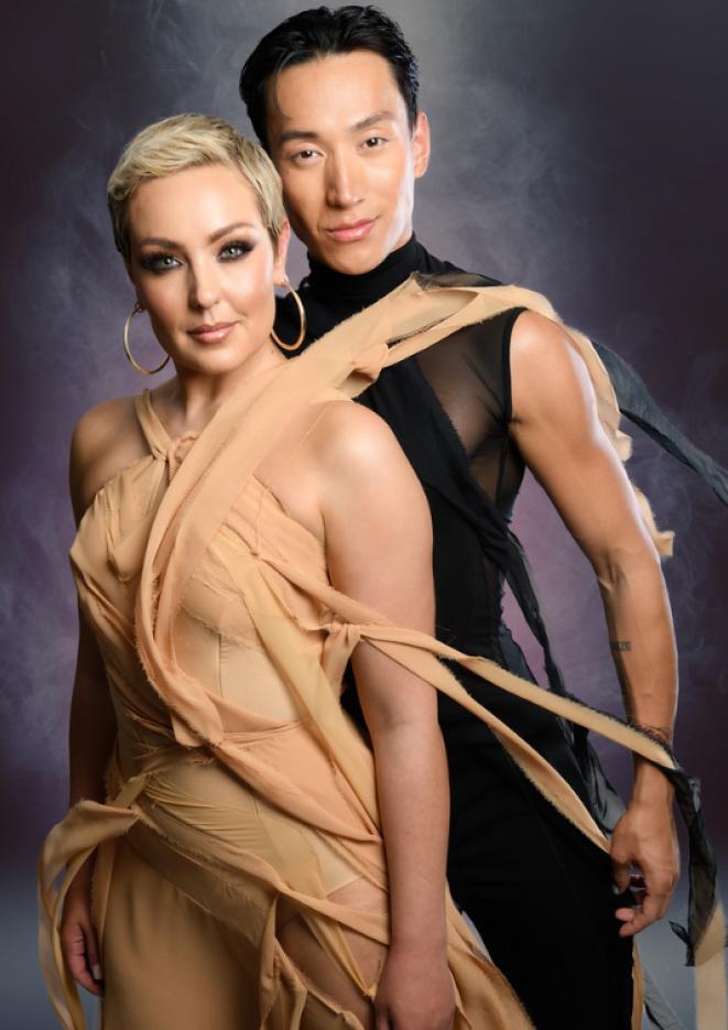 Dancers Amy Dowden and Carlos Gu stand in front of a dark backdrop.