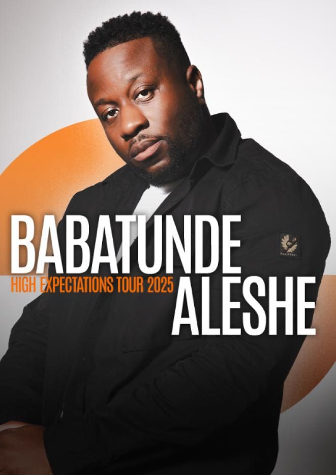 Comedian Babatunde sits in front of a white backdrop with an orange graphic over the top.