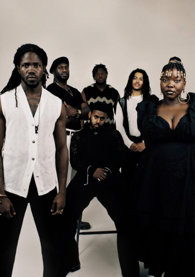 Six people stand against a white background wearing all black and white outfits.